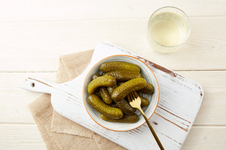 Homemade pickles. Marinated gherkins in a bowl and pickled juice or cucumber pickle. Top view.の写真素材