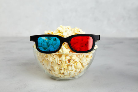 Popcorn, 3D glasses for cinema time on gray background.