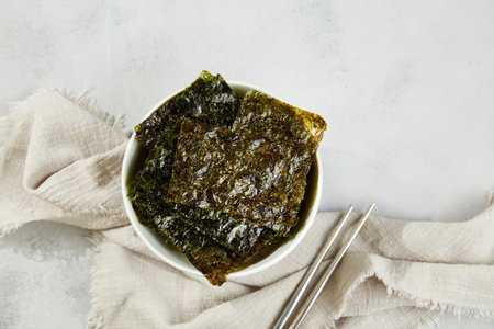 Crispy nori seaweed on bowl on gray background. Traditional Japanese dry seaweed sheets. Healthy...