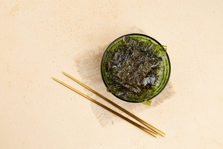 Crispy nori seaweed on green bowl. Traditional Japanese dry seaweed sheets. Healthy snack. Top view.の写真素材