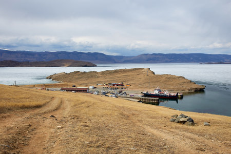 Spring landscape on a cloudy day. Passenger ferry at the pier in spring. The period of ice melting on Baikal.の写真素材