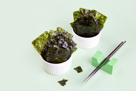 Crispy nori seaweed in a bowl on a light background. Traditional Japanese dry seaweed sheets. Healthy snack.の写真素材