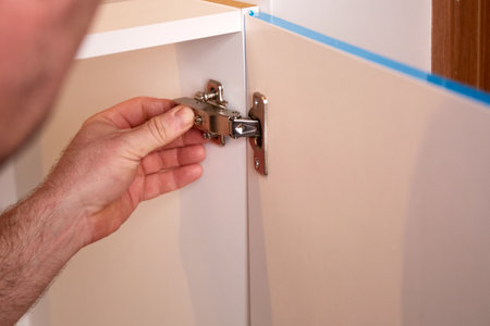 Installing a furniture hinge on the door. Assembling furniture and fixing fittings