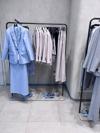 A showcase of stylish women's clothing with suits and skirts in a modern retail store.の写真素材