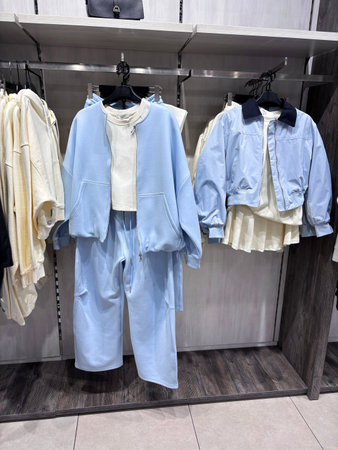 The contemporary clothing boutique features a fashionable collection of casual clothing hanging on hangers.の写真素材