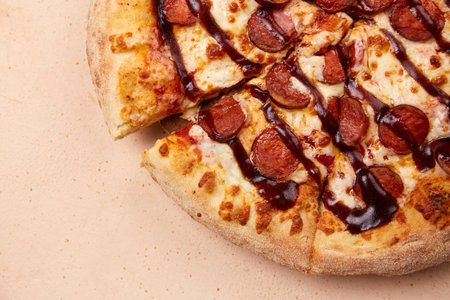 An appetizing sausage pizza, freshly made from the oven, with a generous layer of cheese and juicy barbecue sauce, is perfect for any celebration. Close-upの写真素材