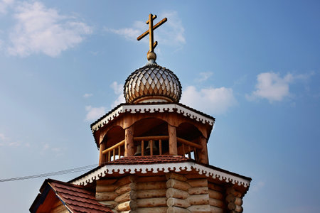 The wooden church is decorated with a carved dome topped with a cross.の写真素材