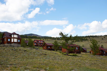 A tourist center with wooden houses in a rustic style against the backdrop of hills and trees.の写真素材