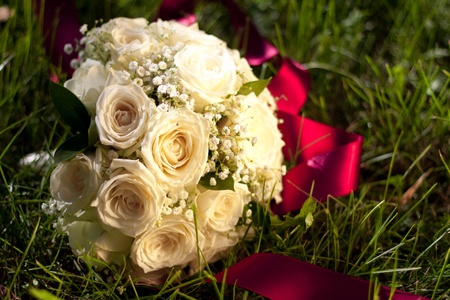 Bridal bouquet of white roses lay in the grassの写真素材