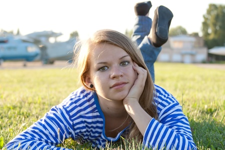 beautiful girl in the shirt on the grass outdoors shootingの写真素材