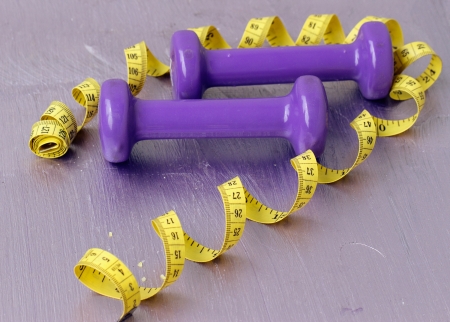 dumbbells and tailoring meter on a purple backgroundの写真素材