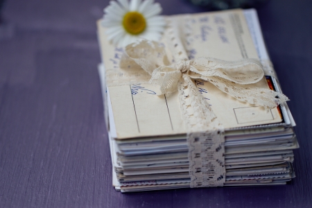 stack of old letters tied with lace ribbon with chamomileの写真素材