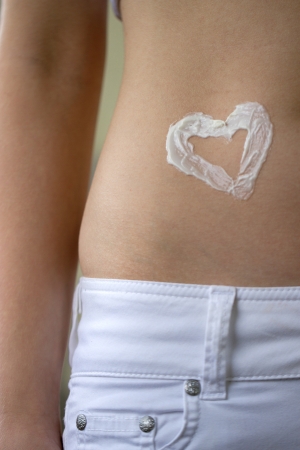 Belly with heart shape made from moisturizerの写真素材