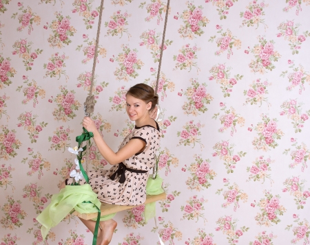 Cute woman sitting on the swingの写真素材