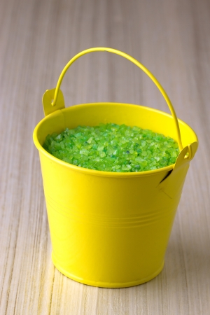 Small yellow bucket with a green sea saltの写真素材