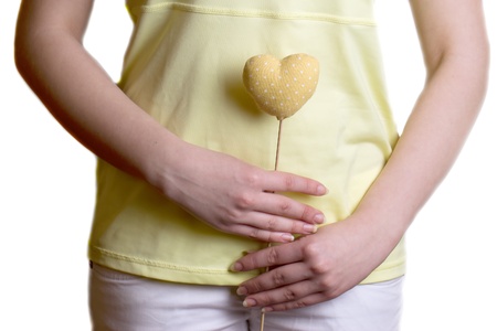 Yellow heart with polka dots on a stick in the hands of the girl