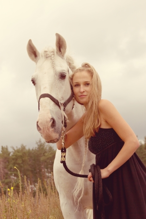 beautiful young woman with a  horse in the forestの写真素材