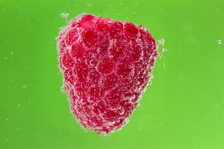 raspberries with bubbles in waterの写真素材