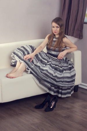 girl in a beautiful lush dress sitting on the couchの写真素材