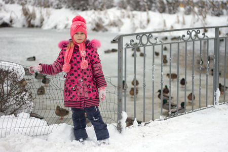 Little girl in winter pink hat in snow.の写真素材