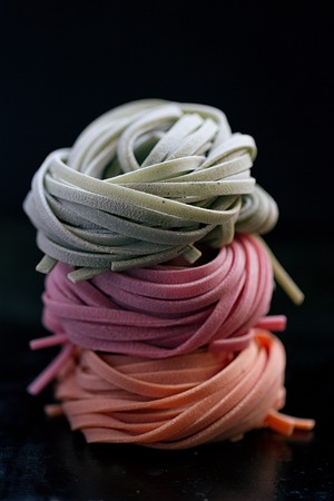 colorful pasta tagliatelle on a black backgroundの写真素材