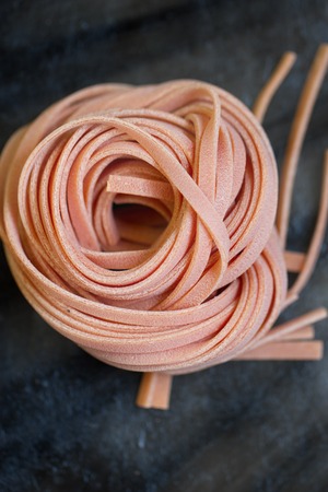 raw dry nest pasta with reflection on blackの写真素材