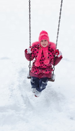 A little girl playing in a snow pile.の写真素材