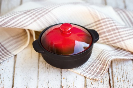 Red borsch. The traditional Ukrainian dish. In a small saucepan. On the white table