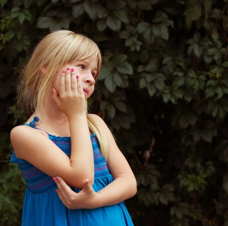 Thoughtful girl of 6 years on a green background