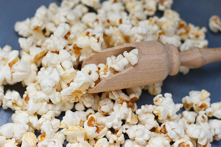 A lot of popcorn and a small wooden spatulaの写真素材