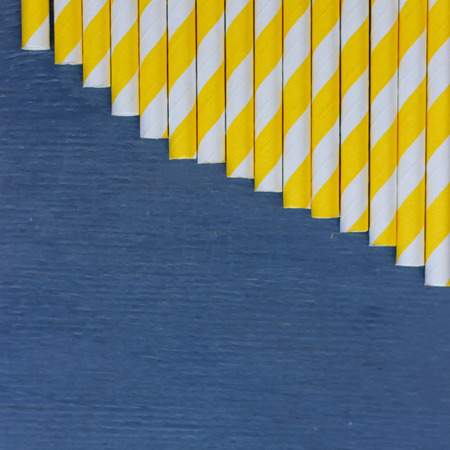 Striped straws for cocktails on blue wooden backgroundの写真素材