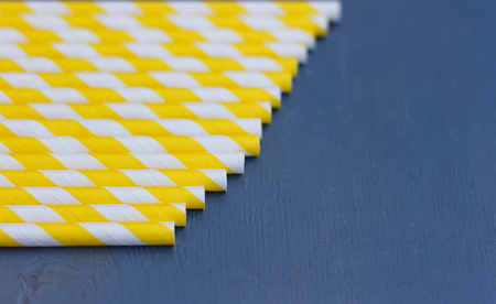 Striped straws for cocktails on blue wooden backgroundの写真素材