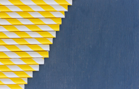 Striped straws for cocktails on blue wooden backgroundの写真素材