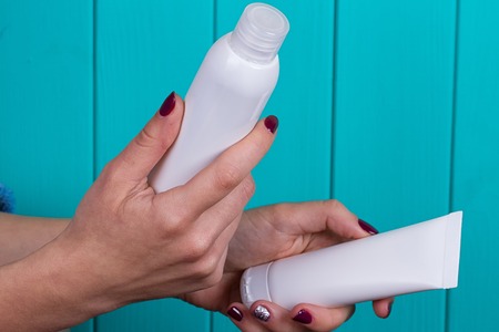 Close view of girl's hand with a 2 white tubeの写真素材