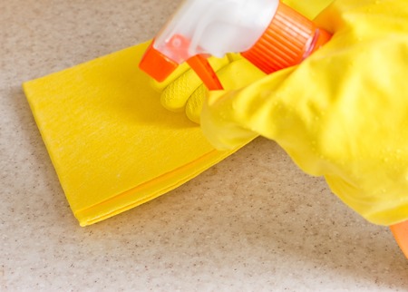 Hand in rubber glove cleans a new kitchen. Woman with housework, cleaning the kitchen.