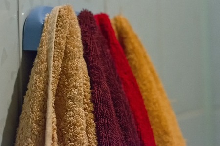 Multicolored towels hang on the hook in the bathroom homeの写真素材