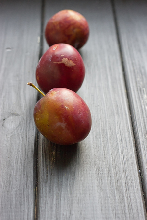 fresh plums on the black wooden tableの写真素材