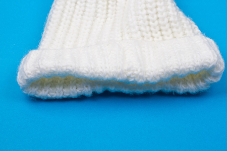 White winter knitted cap on blue backgroundの写真素材