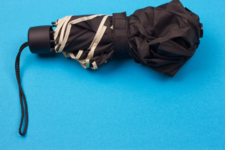 closed black umbrella on the blue backgroundの写真素材