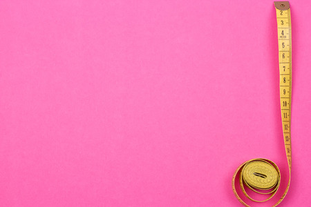 Measuring tape of the tailor on the pink backgroundの写真素材