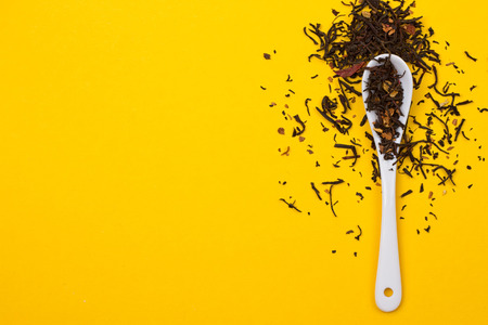 Tea composition with spoon on yellow backgroundの写真素材