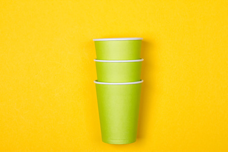 Set of green paper cups on a yellow backgroundの写真素材