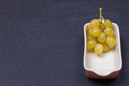 White grapes in a bowl on a black background.copy-spaceの写真素材