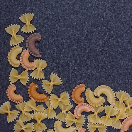 Variety of types of Italian pasta background. Set of raw dry pasta on a black slate background.の写真素材