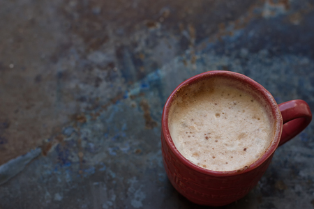 Hot coffee latte cappuccino witl milk foam in vintage ceramic cup on texture background.の写真素材