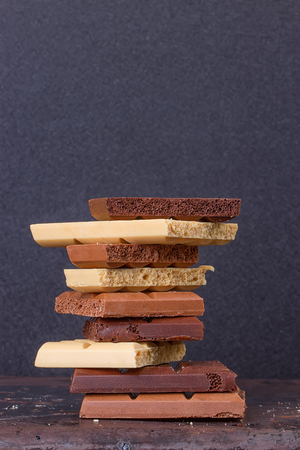 stack of different kind porous chocolate pieces on a dark background.の写真素材
