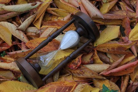 old hourglass over leaves bacgroundの写真素材