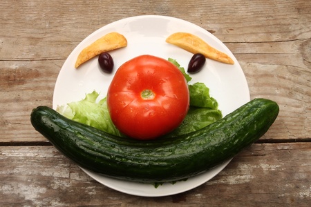 funny vegetables face in plateの写真素材
