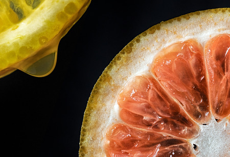 Lemon and orange isolated on black backgroundの写真素材