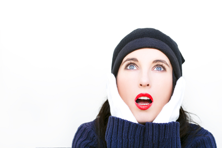 Young beautiful woman in winter clothes and looking up - isolated on white backgroundの写真素材